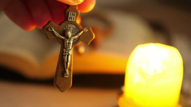 cross with Christ Jesus in twilight illuminated by candle light