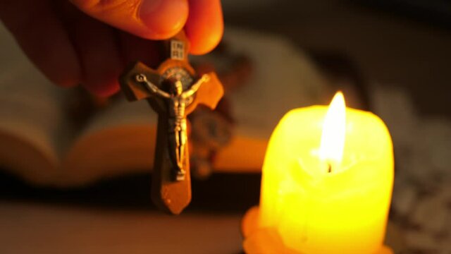cross with Christ Jesus in twilight illuminated by candle light