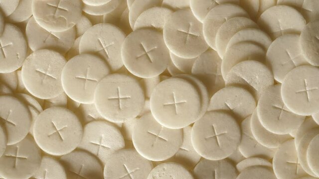communion hosts sacramental breads turning round rotating flat lay top view