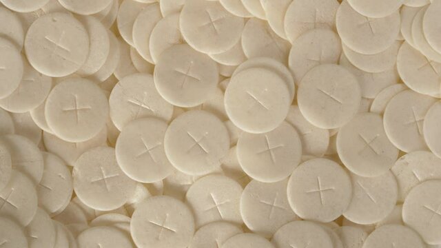 communion hosts sacramental breads turning round rotating flat lay top view