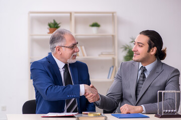 Two businessmen and meditation balls on the table