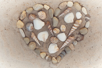 Fototapeta na wymiar a heart of shells and stones on the beach