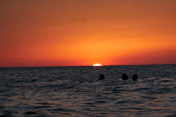 Naklejka premium People bathing in Cala El Frailecillo in Calas de Roche de Conil de la Frontera during sunset. Cadiz Andalusia. Spain