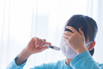 Japanese woman measures fever with thermometer