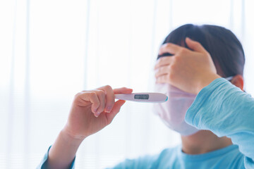 Japanese woman measures fever with thermometer
