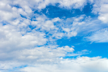 Naklejka na ściany i meble white cumulus clouds on a blue sky, bright sunny day, beautiful natural landscape.
