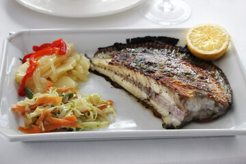 Grilled turbot with vegetable garnish and a lemon slice
