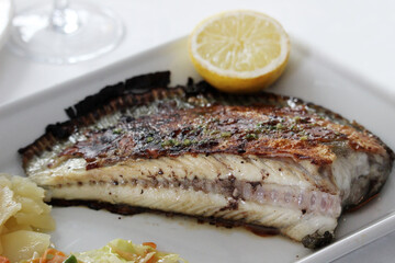 Grilled turbot with vegetable garnish and a lemon slice
