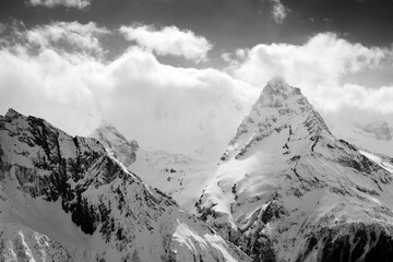 Obraz premium Winter snowy sunlight mountains in clouds and fog