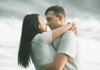 Happy young couple of asian woman and caucasian man is sharing smile and walking in countryside. Concept of mixed race couple in love. Female is hugging her husband. Love. Interracial family.