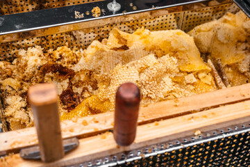 The texture of the honeycomb. Thin layers of honey lie in a pile. A lot of beeswax and honey on it, the remains after removing the honey from the frames of the hive. Beekeeping.