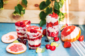 Desserts in glasses with strawberry, raspberry, ice cream and grapefruit