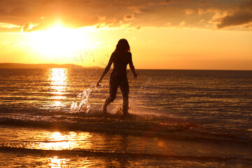 Młoda dziewczyna pozuje do zdjęć w trakcie zachodu słońca