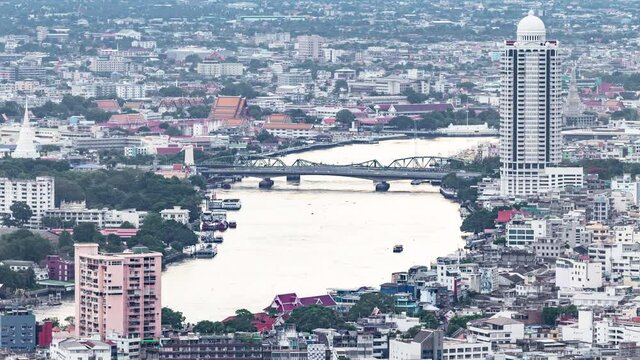 Timelapse of aerial view of Bangkok city over Chao Phraya River and also Memorial Bridge and Phra Pok Klao Bridge
