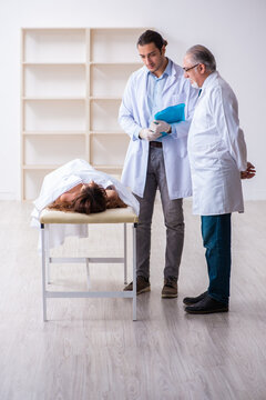 Police coroner examining dead body corpse in morgue
