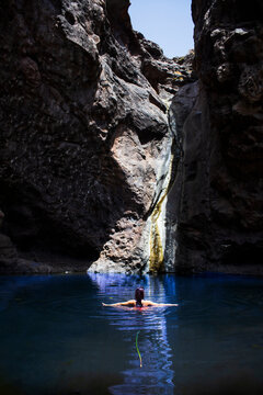 Vista trasera de una joven excursionista ba&ntilde;&aacute;ndose en el lago