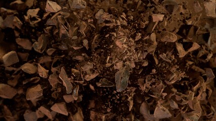 Freeze motion of flying group of raw chocolate pieces.