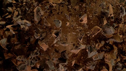 Freeze motion of flying group of raw chocolate pieces.