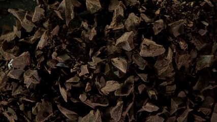 Freeze motion of flying group of raw chocolate pieces.