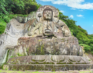 Naklejka na ściany i meble Largest stone-carved magaibutsu statue of giant buddha Daibutsu of Nihonji temple on the mountain sides of Mount Nokogiri stone quarry in the forest of the Boso peninsula.
