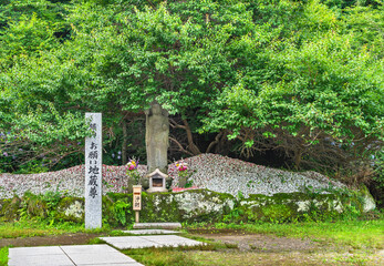 Fototapeta premium Buddhist statue of Jizō bosatsu named Onegai-Jizōson or Make a Wish to Jizō surrounded by thousands of amulets deposited by faithful at Nihonji temple of Mount Nokogiri.