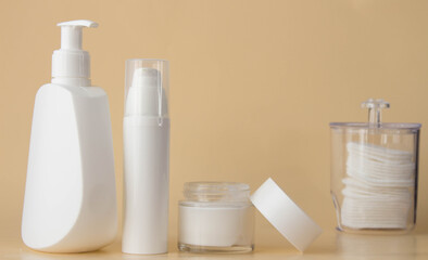 Cosmetics for cleansing and caring skin on pale beige background,  mockup. Health care concept.