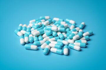 Blue and white medical capsules on a blue background