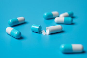 Blue and white medical capsules on a blue background