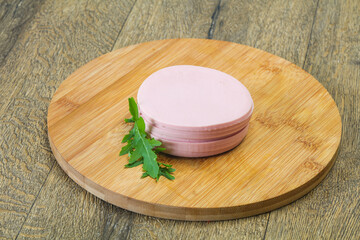 Sliced sausage over the wooden board