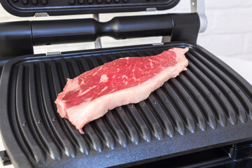 A piece of fresh meat. Juicy beef steak on the electric grill. - 368850059
