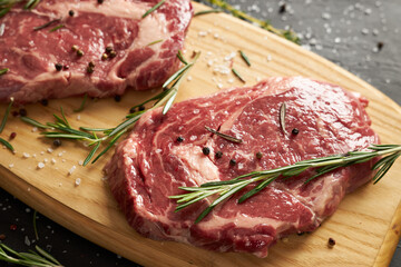 Two raw beef slices for barbecue on wooden board.