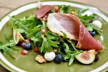Rocket salad with prosciutto parma ham and berries fruit, Healthy diet food full of good vegetable and nutrition, Refreshing appetizer.