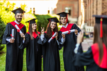 Graduation friends students take picture on the camera in front of University