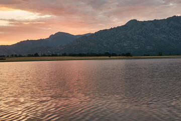 Sunset in the Santillana Reservoir with La Pedriza and the Sierra de Guadarrama in the background. Madrid's community. Spain