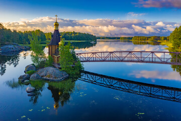 Church on a rocky island. Orthodox Church in the middle of the water. Church in the natural landscape. Religious building. Chapel on the island. Natural landscape with a chapel.