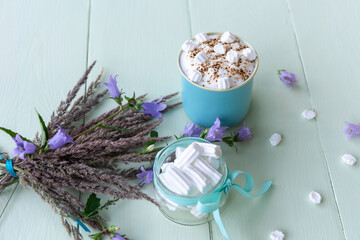 Hot chocolate with delicious marshmallows in a blue Cup in the early morning.