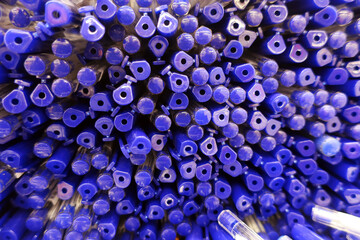a lot of ballpoint pens with blue caps stacked
