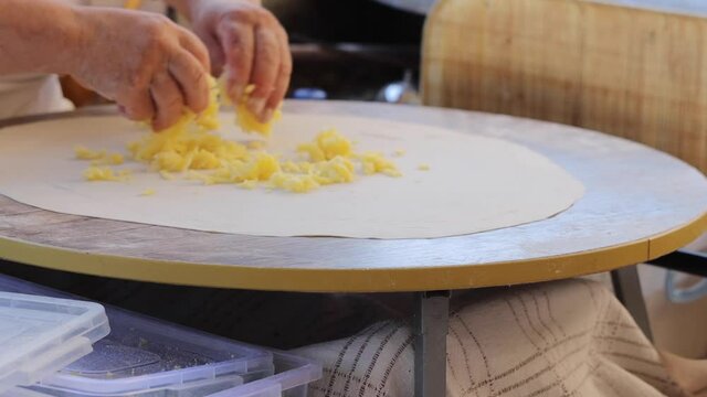 Making gozleme dough by close up female hands in kitchen. Shaping dough is precursor to making a wide variety of food stuffs, particularly breads.