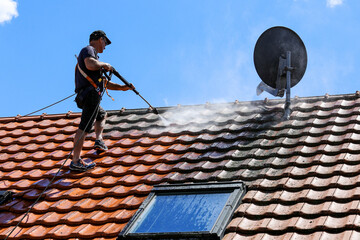 Roof cleaning with high pressure cleaner - obrazy, fototapety, plakaty