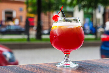 Alcoholic cocktail in a street restoraunt. Beer cocktail with a lemon and cherry
