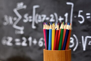 Lápices de colores, con fondo de una pizarra