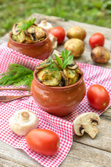 Baked potatoes with chicken and mushrooms with the addition of different seasonings. in clay pots. In nature