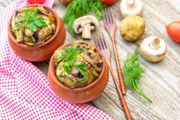 Baked potatoes with chicken and mushrooms with the addition of different seasonings. in clay pots.