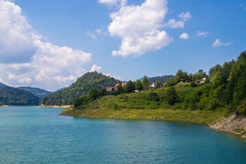 Obraz premium Beautiful Zaovine lake on Tara national park in Serbia, Europe. Beautiful landscape with cloudy sky, hills, and mountains. Tourism and travel concept