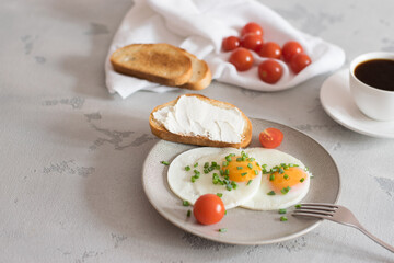 delicious breakfast with fried eggs, fresh tomatoes, green onions, toast and fresh coffee