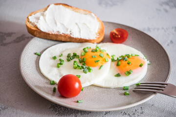 fried eggs with tomatoes, green onions and toast