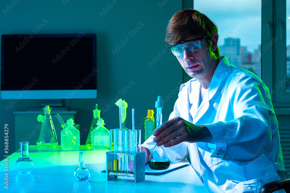 Poster chemist in the lab. a man writes down the results of chemical experiments. scientist on the backgrou