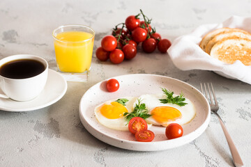 fried eggs with tomatoes and herbs, toast, coffee and juice
