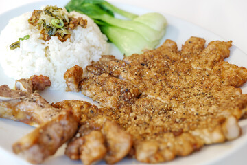 Taiwanese Slice Pork Chop with rice and Pak Choi serve on white plate on white table.  
