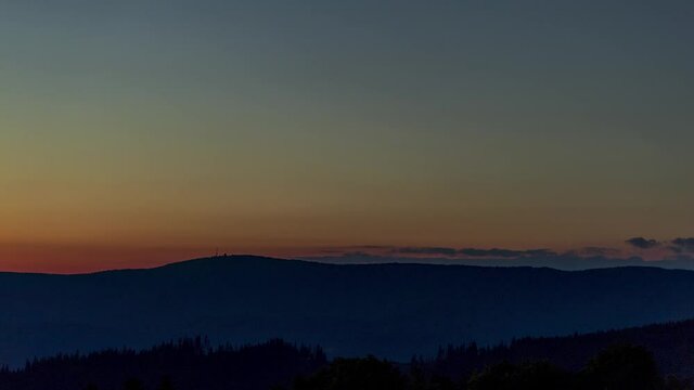 Timelapse to the top of mountains and hills during sunset The hill is shrouded in dark color and in the vicinity the clouds are moving on the hill Radhost is seen by the transmitter.